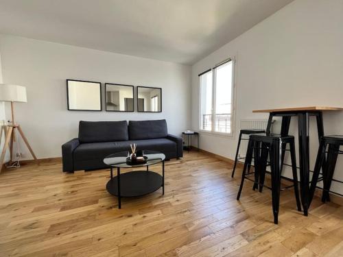 un salon avec un canapé bleu et une table dans l'établissement Appartement Emplacement Idéal de Disney à Paris, à Serris