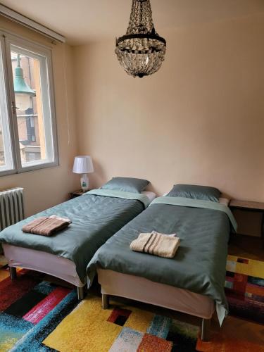 two twin beds in a bedroom with a chandelier at REMSA in Sarajevo