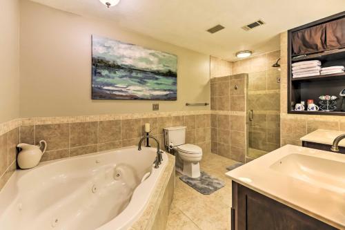a bathroom with a tub and a toilet and a sink at Quiet Lake Conroe Townhome with Water-View Deck in Willis
