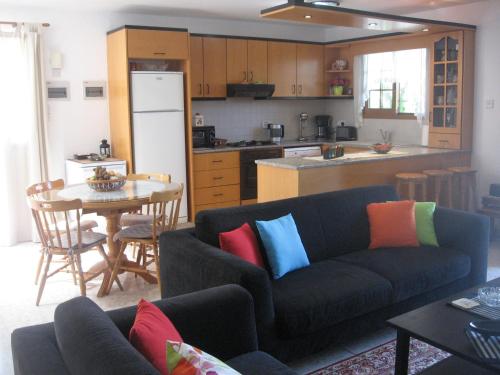 a living room with a couch and a kitchen at Zena Holiday Villa in Pissouri