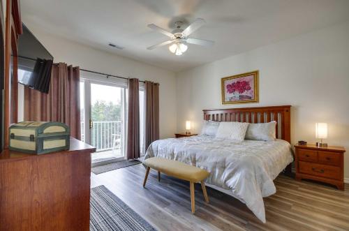 een slaapkamer met een bed, een plafondventilator en een televisie bij Lakefront Osage Beach Condo Dock Your Boat Here! in Osage Beach