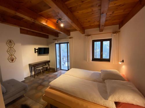 a bedroom with a bed and a desk in it at Osteria Vittoria in Lavertezzo
