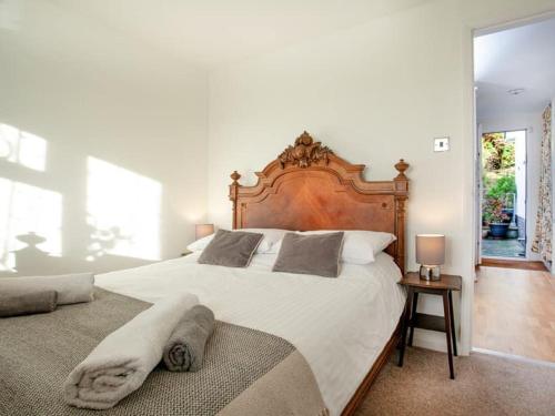 a bedroom with a large bed with a wooden headboard at Waterside Park Annex in Kingsbridge