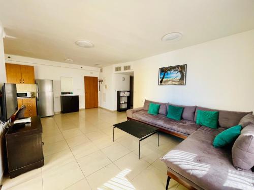 een grote woonkamer met een bank en een keuken bij King David Apartment in Netanya