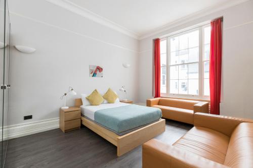 1 dormitorio con 1 cama y 1 sofá en Stay Hyde Park, en Londres