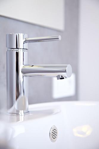 a bathroom sink with a chrome faucet at Road House Hotel in Paderborn