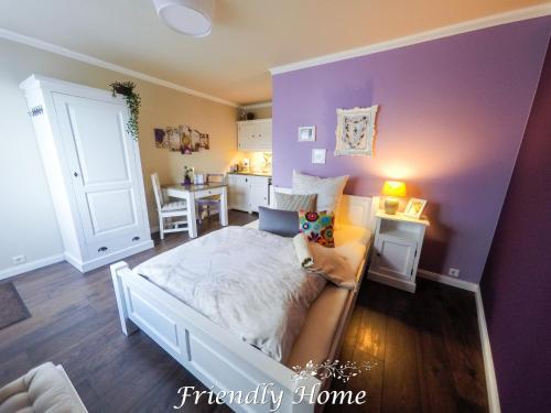 a bedroom with a bed and a purple wall at Friendly Home - Doppelappartement "Purple" Köln Bonn Phantasialand in Brenig