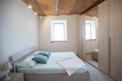 ein Schlafzimmer mit einem Bett mit blauen Kissen in der Unterkunft Casa Dolce Casa _ a due passi dal Lago Maggiore in Angera