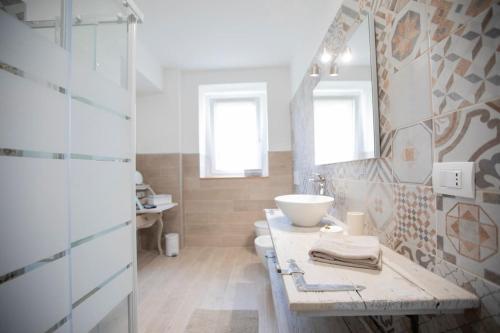 Baño blanco con lavabo y aseo en Casa Dolce Casa _ a due passi dal Lago Maggiore en Angera