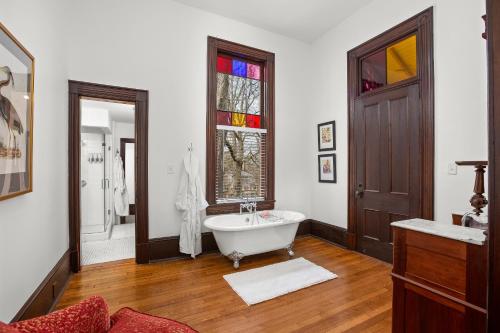 a bathroom with a white tub and a window at Summit Street Inns in Winston-Salem