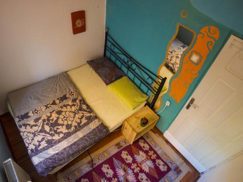 a small bedroom with a twin bed and a guitar on the wall at Shantihome in Izmir