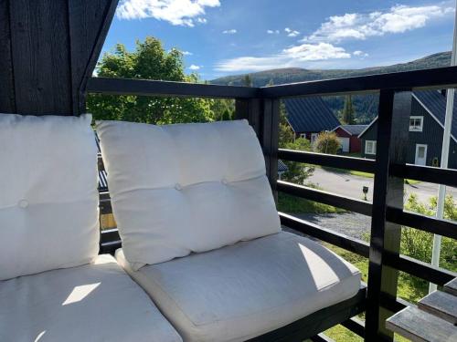 un porche con 2 almohadas en el balcón en Åre Travel - Villa Solbringen eller Lilla Sol, en Åre