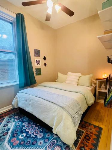 a bedroom with a large bed with a ceiling fan at Sunny, Spacious, 3BR 1BA Davlin INN Chicago in Chicago
