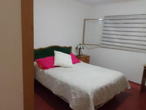 um quarto com uma cama e uma janela em Graciela Chacras Pueyrredón em Ciudad Lujan de Cuyo