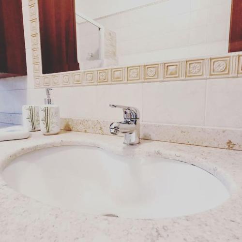 a white sink in a bathroom with a mirror at Casa Vacanze "LA TERRAZZA" in Leporano