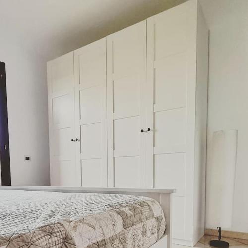 a white bedroom with a bed and white cabinets at Casa Vacanze "LA TERRAZZA" in Leporano