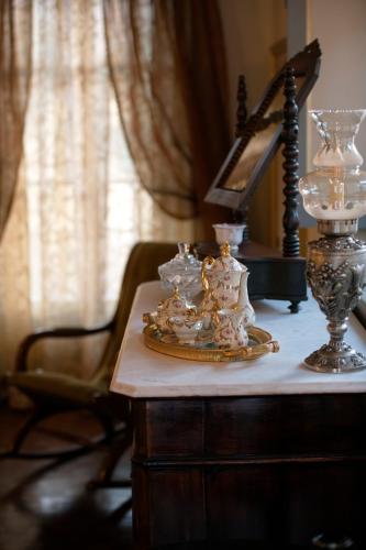 a table with a plate of dishes and a lamp on it at Villa Albaluce in Caluso