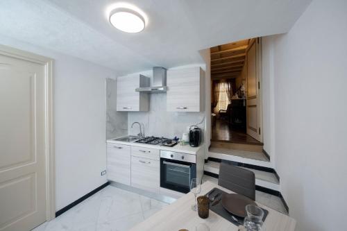 cocina con armarios blancos y mesa de madera en Villa Albaluce, en Caluso