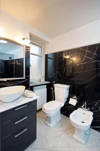 a bathroom with a toilet and a sink and a mirror at Villa Albaluce in Caluso