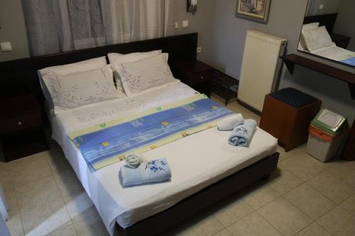 een slaapkamer met een groot bed en handdoeken bij Ellis Studios in Meganisi