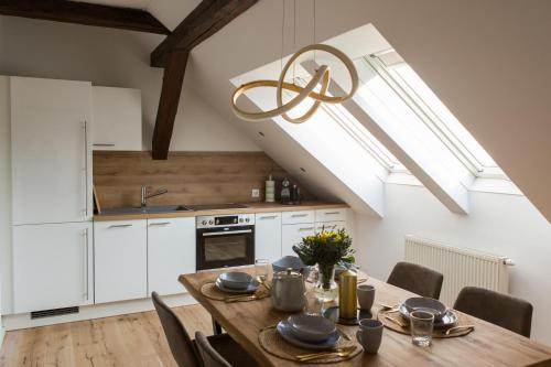 eine Küche und ein Esszimmer mit einem Holztisch in der Unterkunft Modern City Apartment in Graz