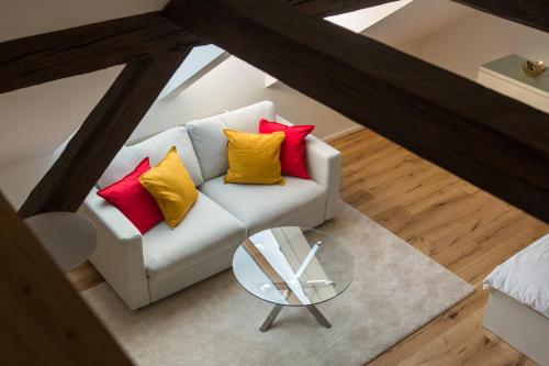 una vista aérea de un sofá blanco con 4 almohadas coloridas en Modern City Apartment en Graz
