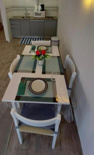 una mesa con sillas y un plato y flores. en Armação de Pêra Lovely Flat 1 Min From the Beach, en Armação de Pêra