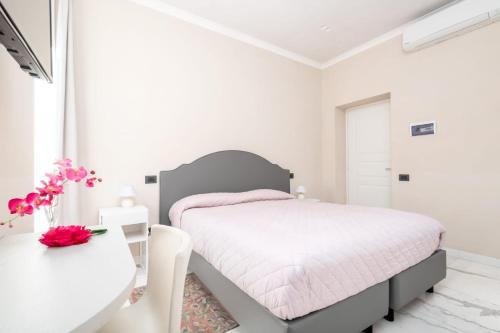a white bedroom with a bed and a desk at Fidelio in La Spezia
