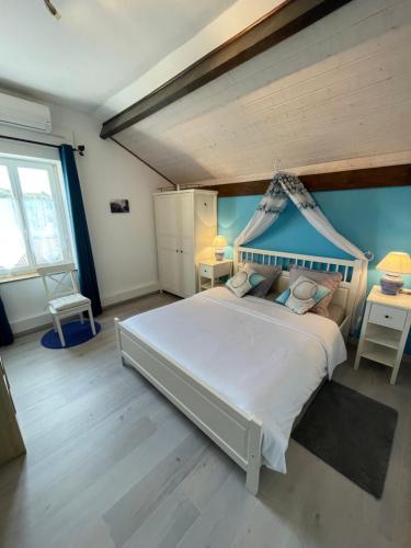 ein Schlafzimmer mit einem großen weißen Bett mit Baldachin in der Unterkunft L'Oustaloise in Faugères