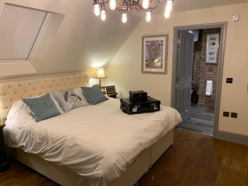 a bedroom with a bed with a suitcase on it at Luxury Boutique Country Cottage with Hot Tub in York
