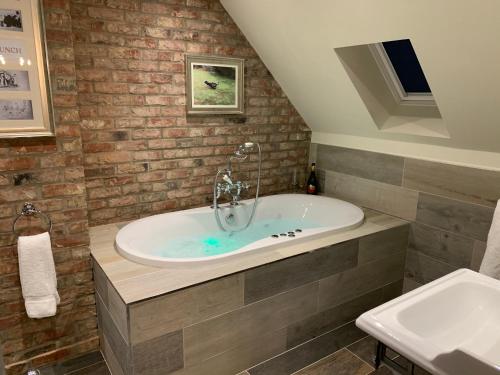 a bathroom with a tub and a sink at Luxury Boutique Country Cottage with Hot Tub in York