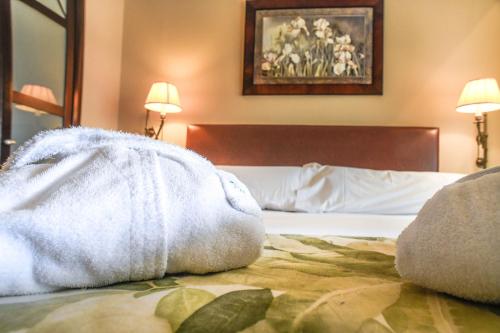 una camera d'albergo con un letto e un asciugamano sopra di Gran Hotel Guadalpín Banus a Marbella