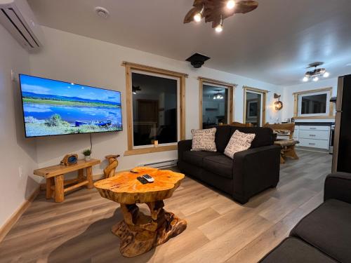 a living room with a couch and a table at Sable Point Cottage (Lakeside 7-Person Hot Tub & Outdoor Shower) in Grand River