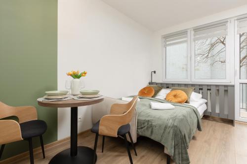 sypialnia z łóżkiem i stołem z krzesłami w obiekcie Cozy Studio Apartment Kolorowa Warsaw Ursus by Renters w Warszawie
