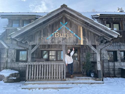 uma mulher em pé na frente de um edifício em Chalet Burja at Vogel mountain - cable car access or hiking - not reachable with car em Bohinj