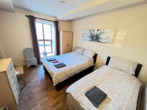 a bedroom with two beds and a window at The Old Post Office Public House & Hotel in Halifax