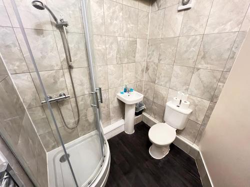 a bathroom with a shower and a toilet and a sink at The Old Post Office Public House & Hotel in Halifax