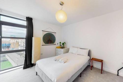 a bedroom with two beds and a window at Modernistic 2-bedroom flat in Shadwell in London