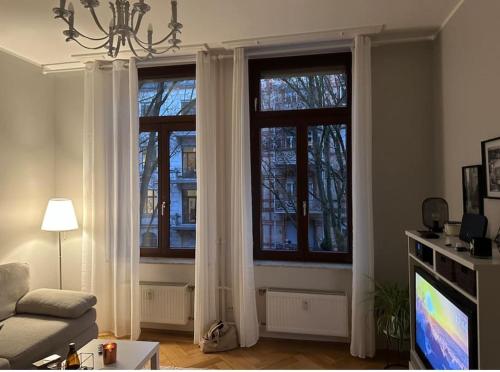 un soggiorno con 2 finestre e tende bianche di APT im Herzen von Wiesbaden a Wiesbaden