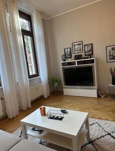 uma sala de estar com uma televisão e uma mesa de centro em APT im Herzen von Wiesbaden em Wiesbaden