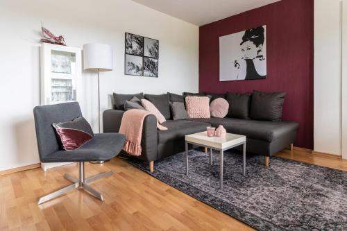a living room with a black couch and a chair at Villa Schönau in Bad Münstereifel