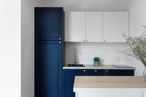 a kitchen with a blue refrigerator and white cabinets at Elite Apartments Hewelius Prestige in Gdańsk