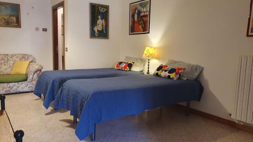 una camera con un letto blu e un divano di Le Casette di Civitella la casa di Nonna Giulia a Civitella Del Lago