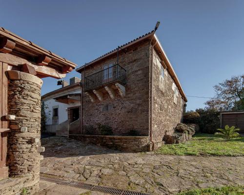 um edifício de tijolos com uma varanda ao lado em A Casacuberta em Marquiño