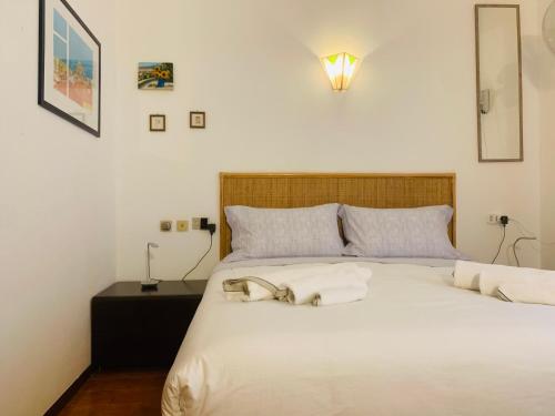 a bedroom with a large white bed with a lamp at Vacanza nella Natura in Punta Ala
