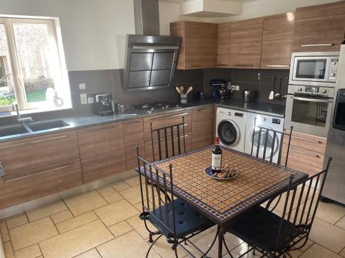 a kitchen with a table with a bottle of wine on it at Manoir de La Brunie-Grand Longere in Coux-et-Bigaroque