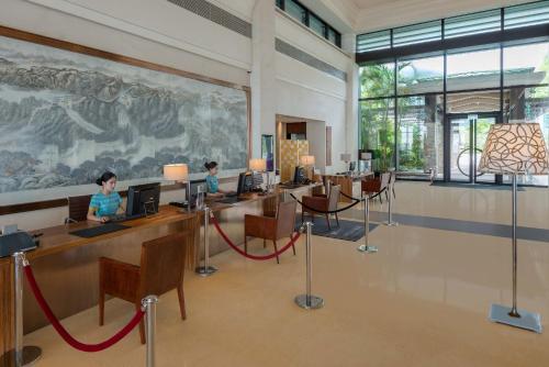 2 niños sentados en los escritorios en una habitación con un gran mural en Crowne Plaza Hailing Island, an IHG Hotel, en Yangjiang