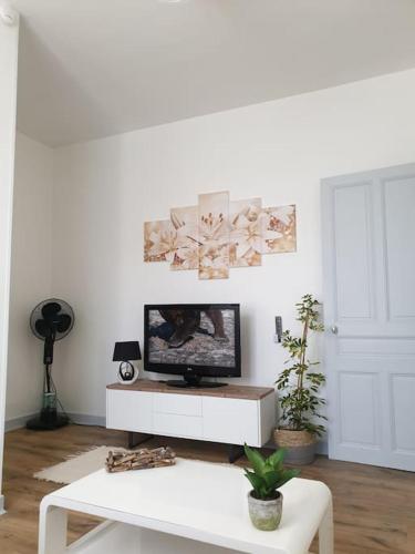 - un salon avec une télévision et une table blanche dans l'établissement Appartement duplexe de 1 à 4 chambres privées dans maison, à Le Teil