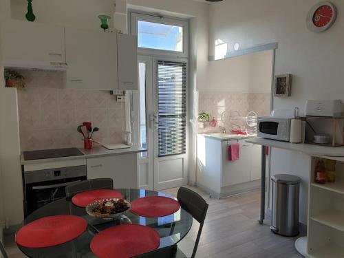 une cuisine avec une table et des chaises dans une cuisine dans l'établissement Appartement duplexe de 1 à 4 chambres privées dans maison, à Le Teil
