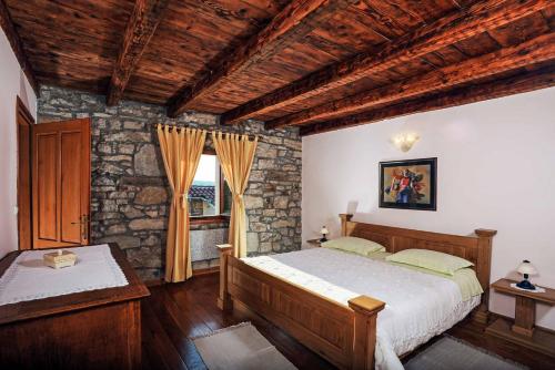 a bedroom with two beds and a stone wall at Villa Stargazer in Kozljak